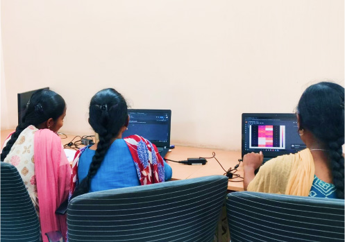 Students coding and analyzing data on laptops at KITEZ